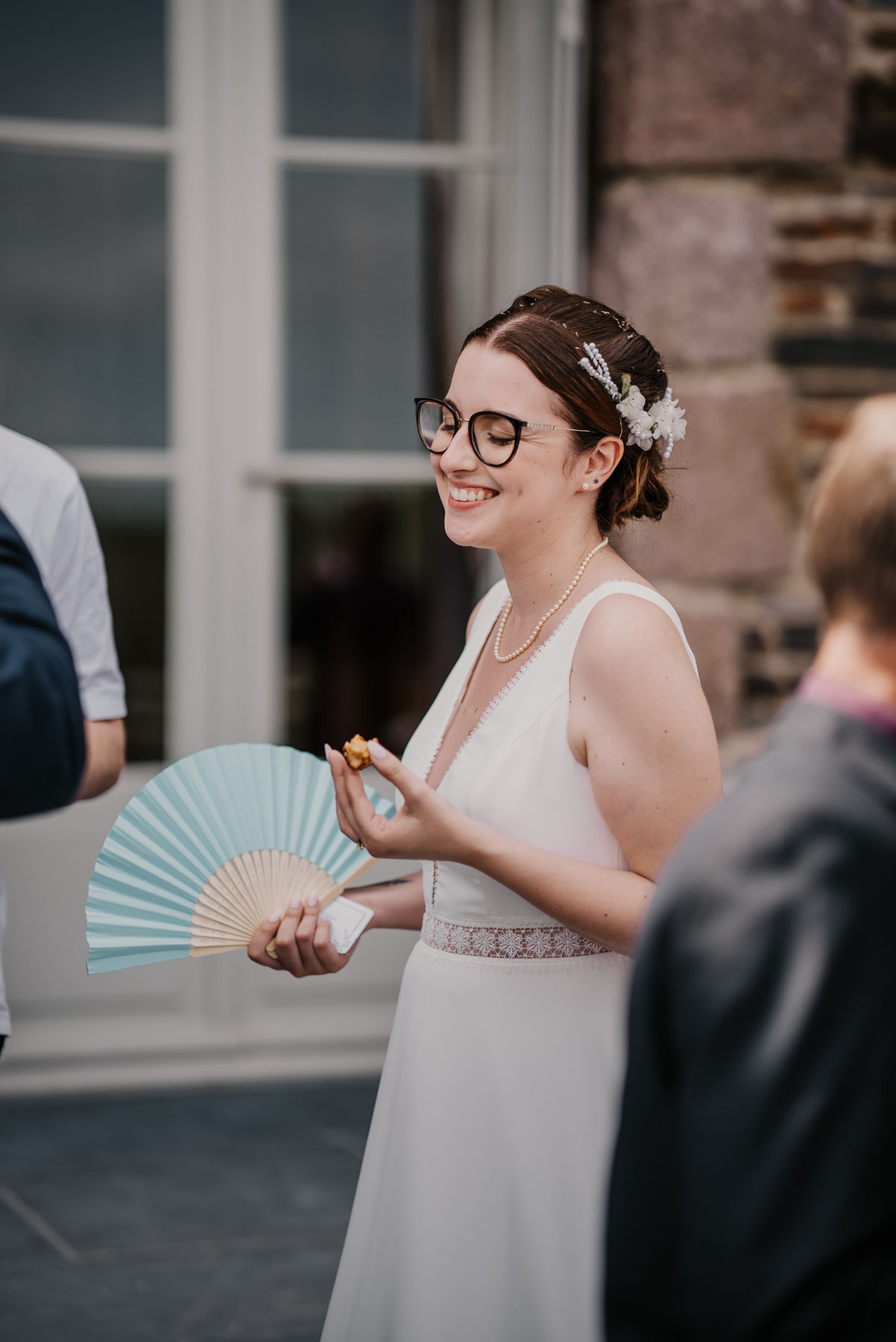 Mariée souriante avec un éventail bleu