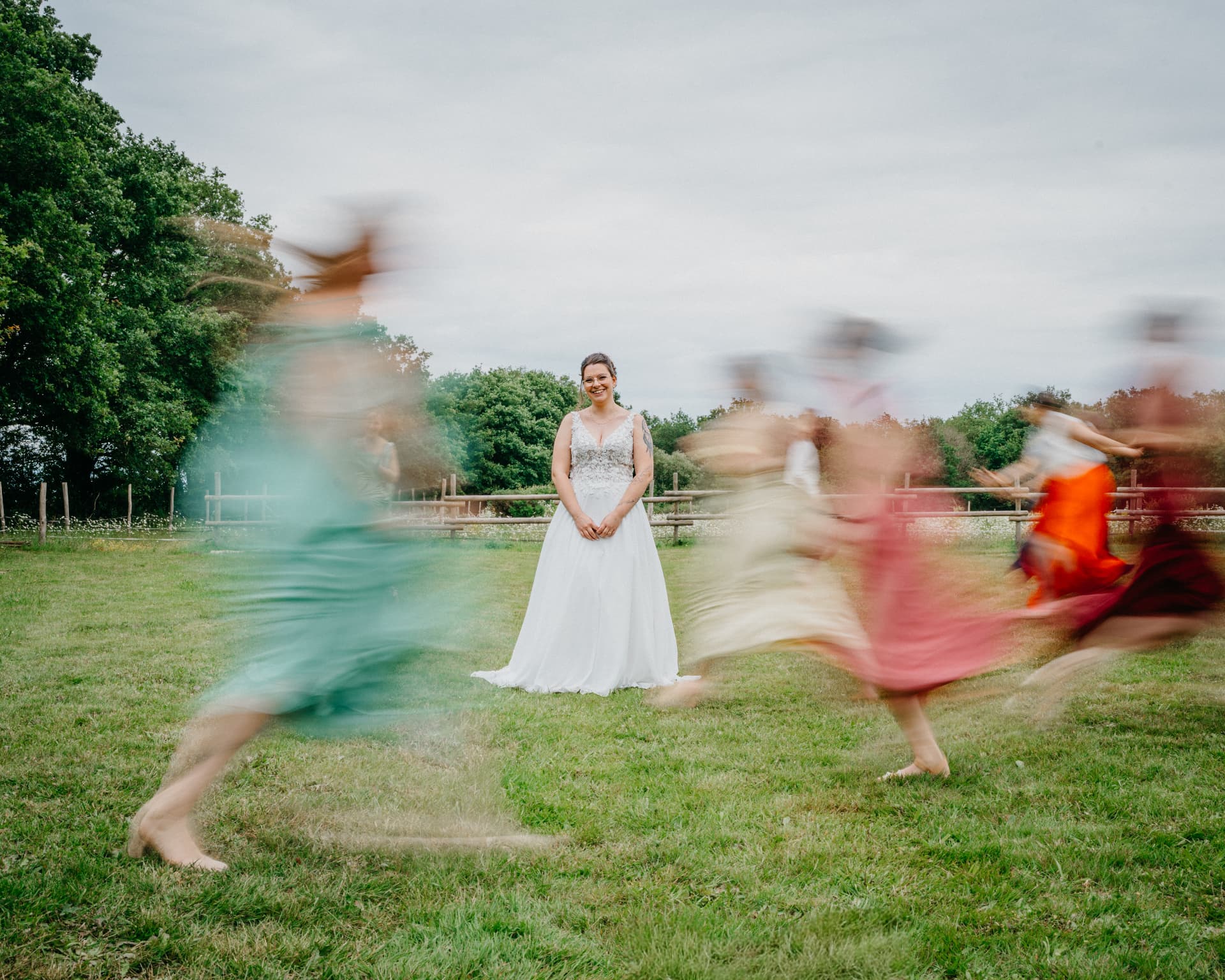 La mariée souriant au centre pendant que ses demoiselles d'honneur tourbillonnent autour d'elle
