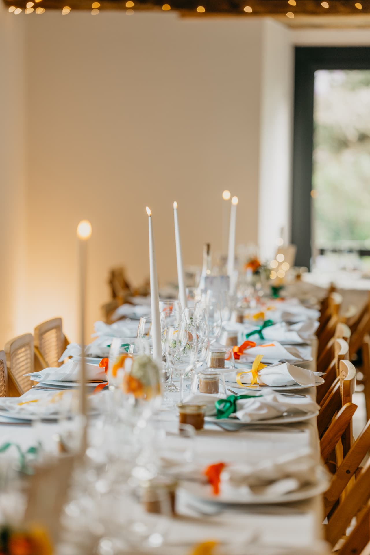 Table de réception dressée avec verres, serviettes et longues bougies allumées