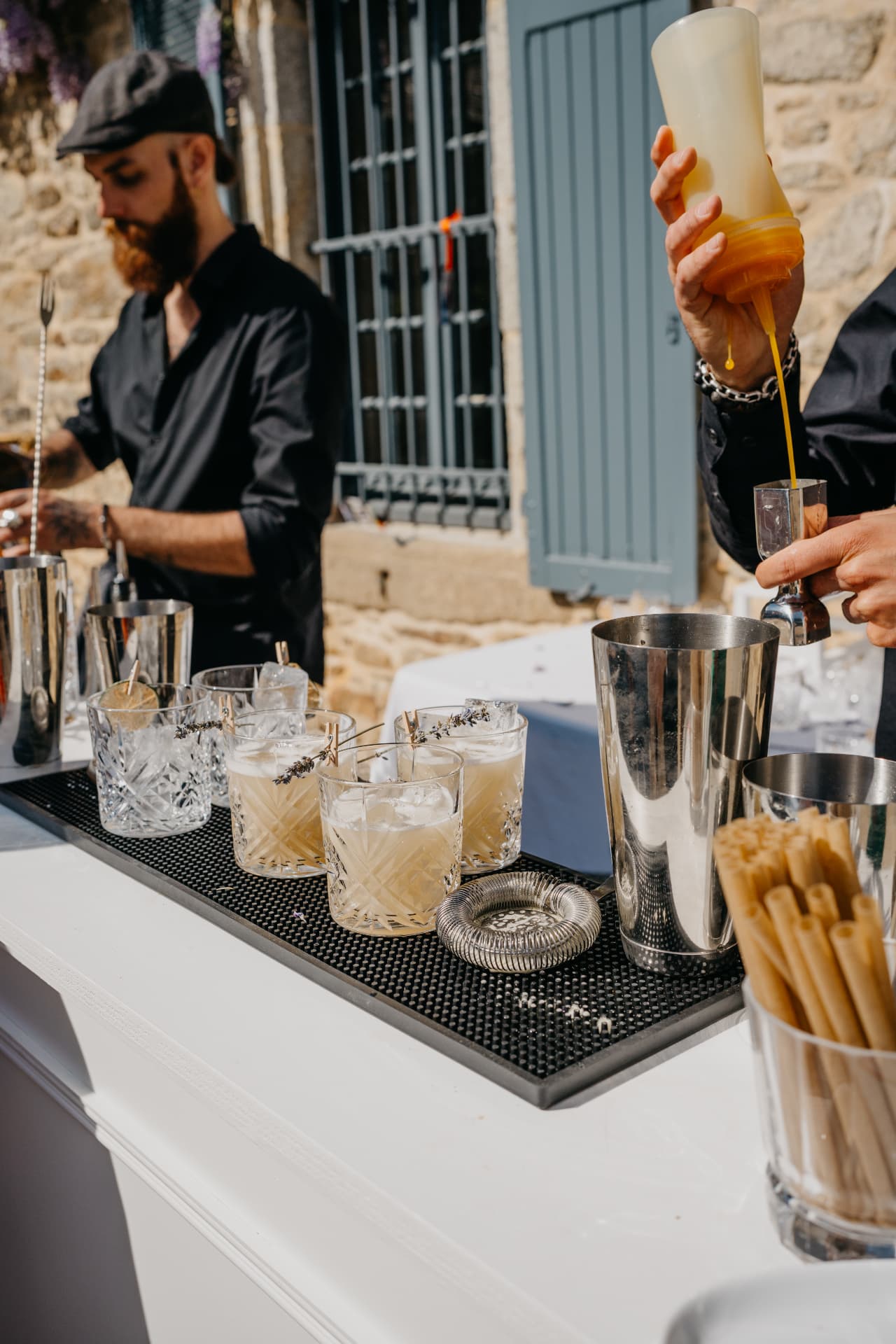 Cocktails garnis de lavande et shakers alignés sur le bar du mariage
