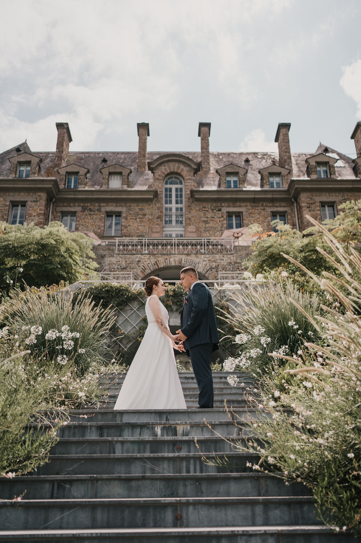Couple de mariés sur les marches d'un château
