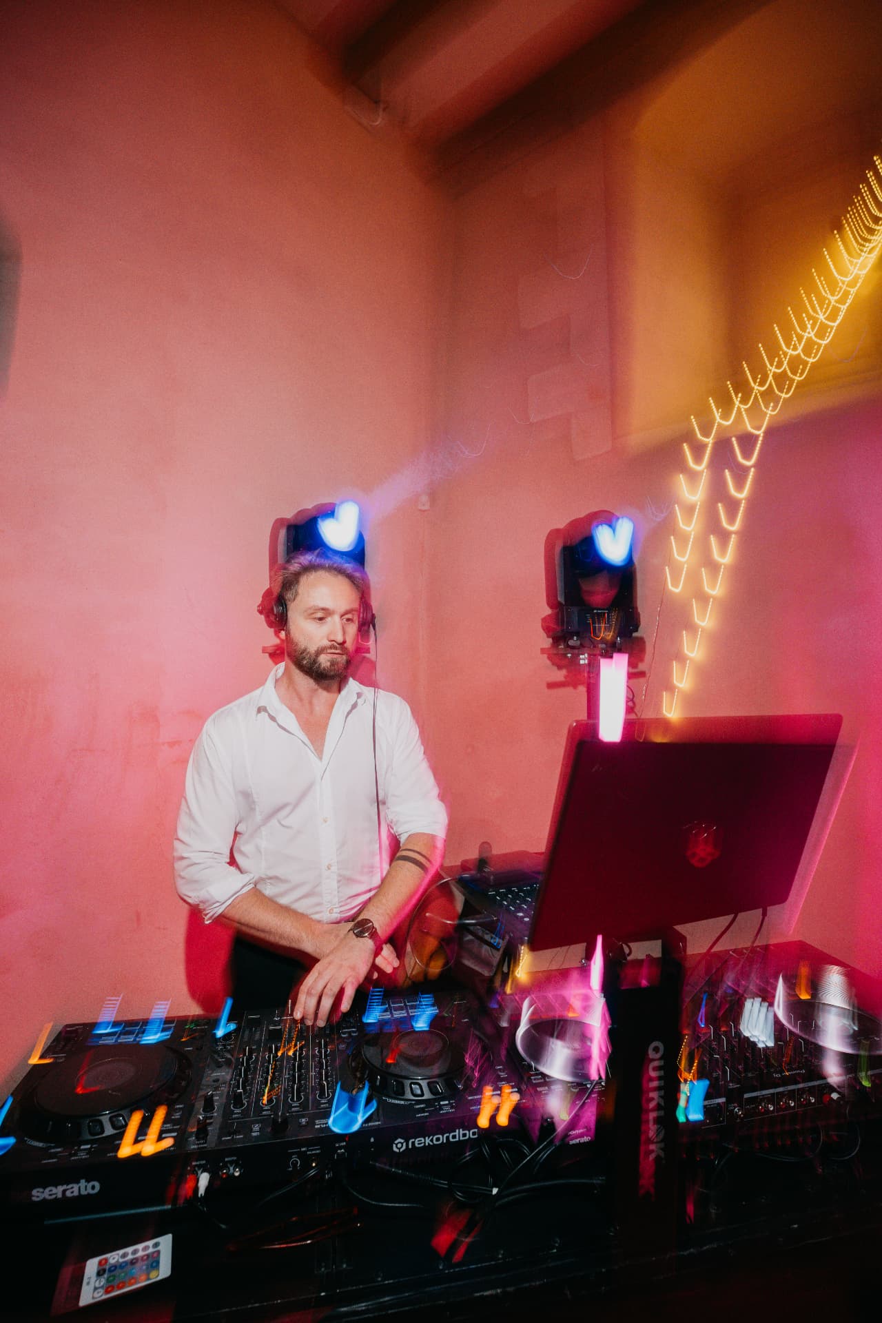 DJ SPO aux platines, casque sur les oreilles, pendant une soirée de mariage
