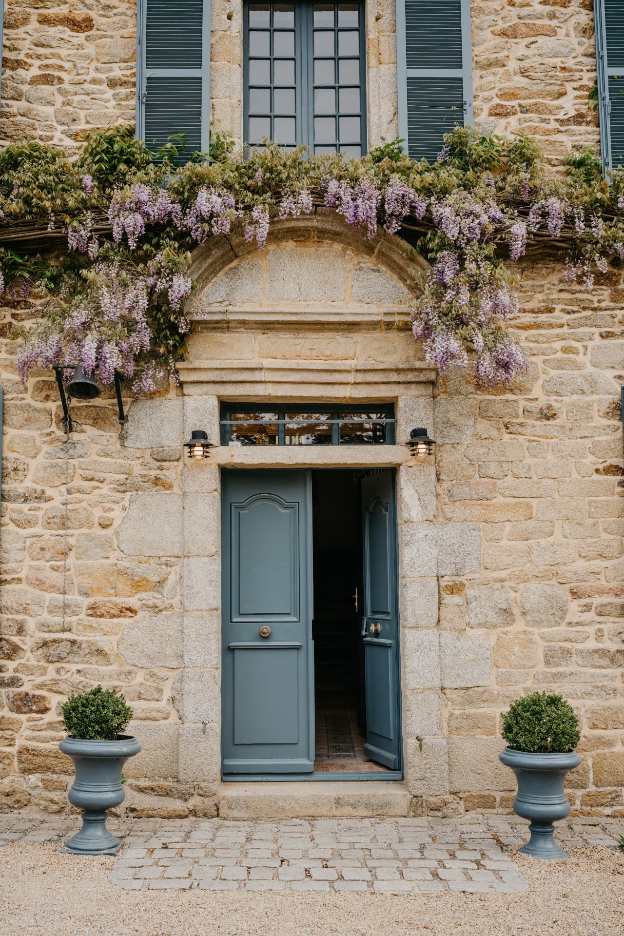 Entrée d'un manoir, grandes portes ouvertes sous la glycine