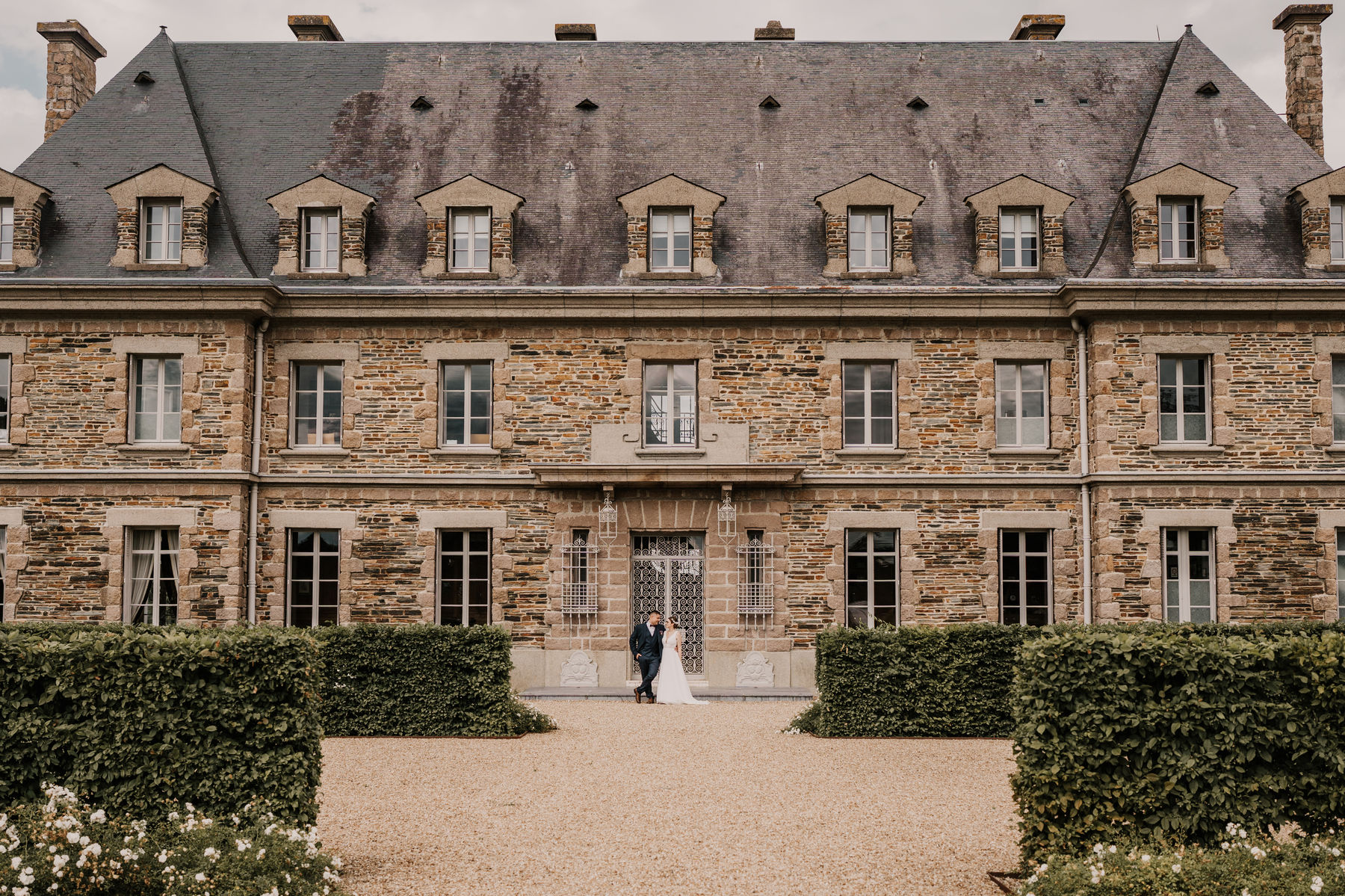 Mariés devant la façade d'un château en pierre