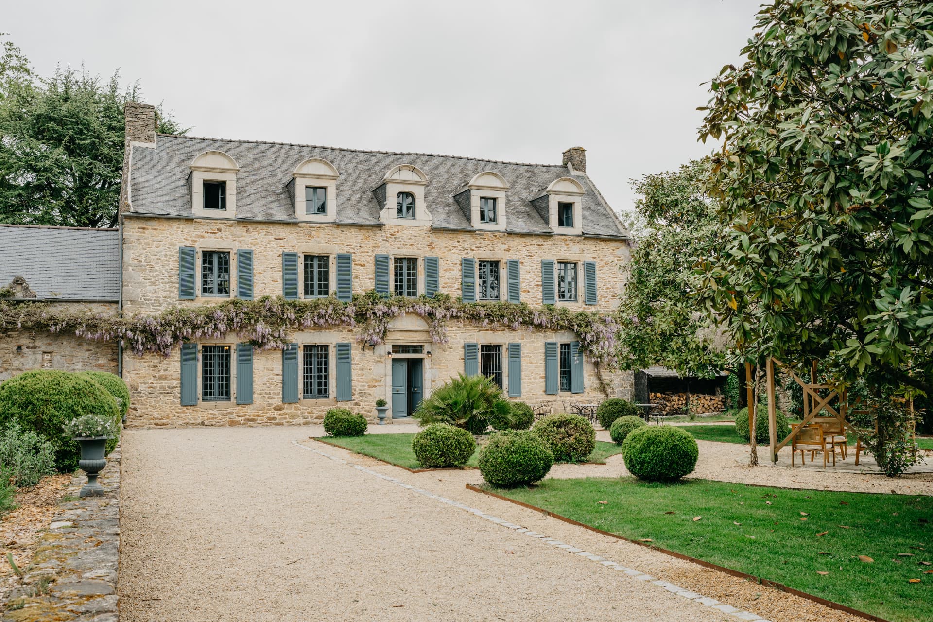 Façade d'un manoir de pierre aux volets d'ardoise, lieu de réception