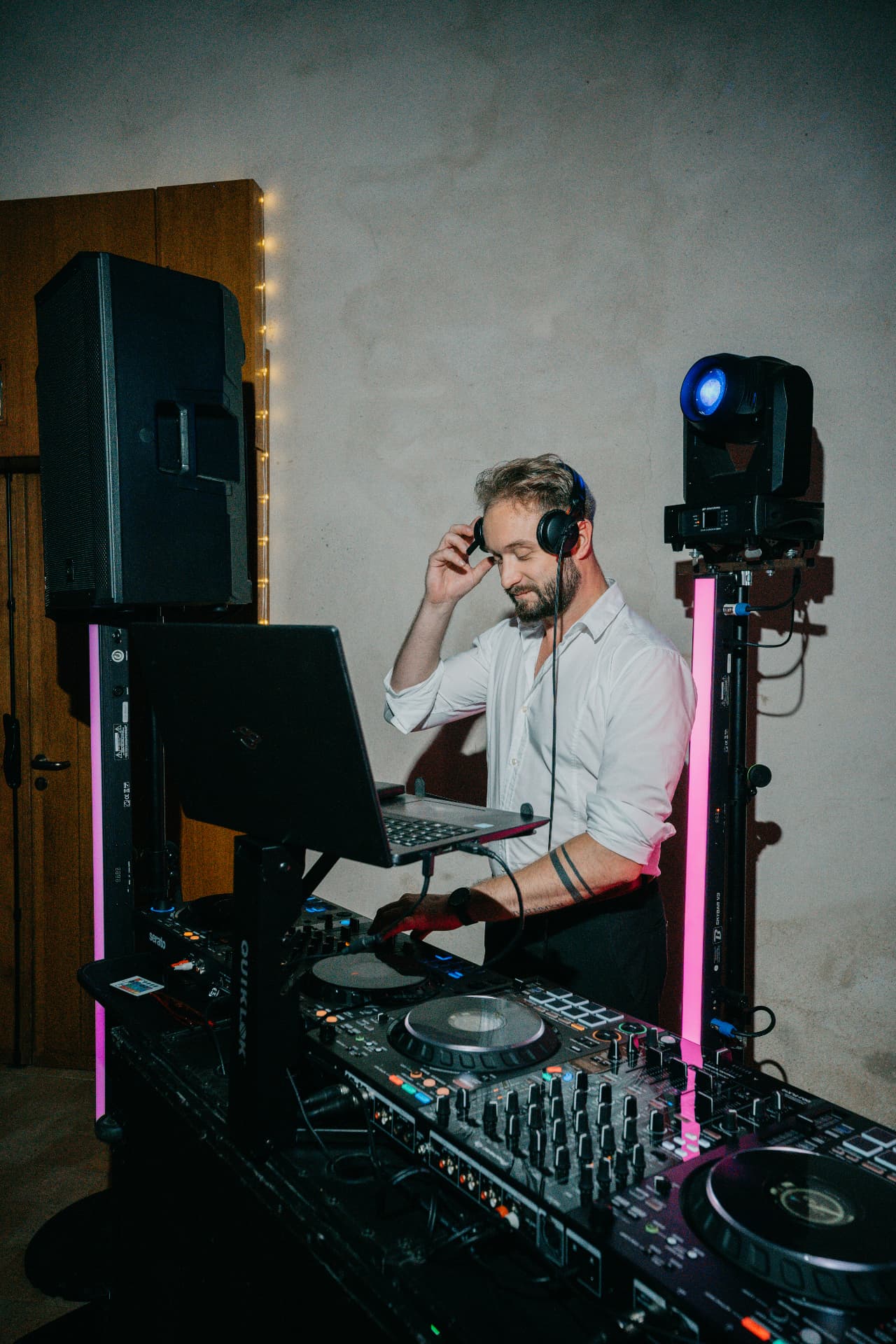 Le DJ SPO derrière ses platines, éclairé par des tubes LED roses