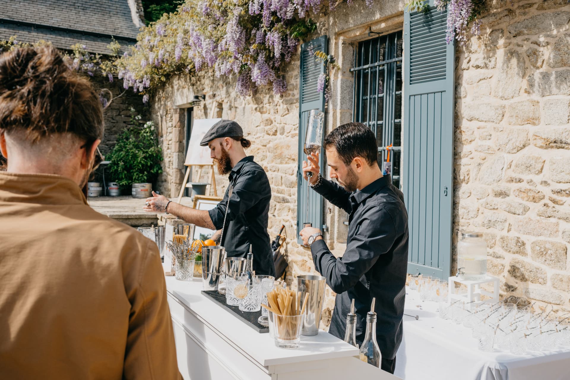Deux barmen préparant les cocktails au bar extérieur d'un mariage